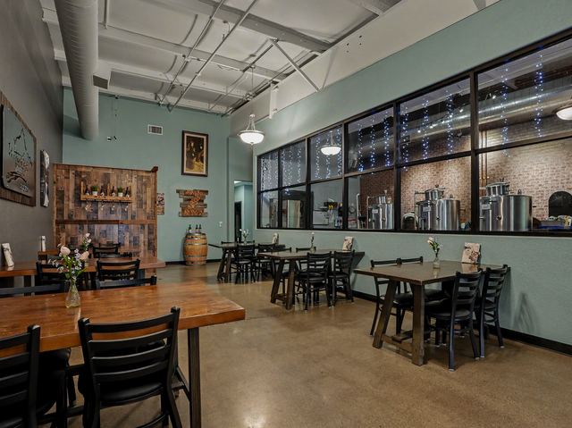Dining tables beside interior windows looking into the production room