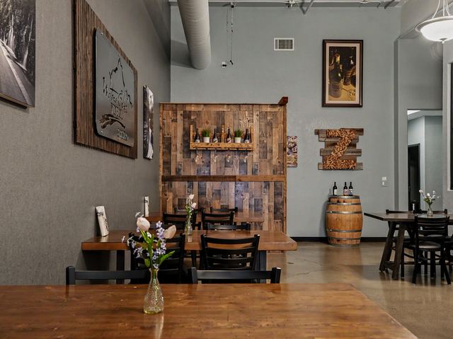 Dining area with reclaimed wood accent wall and bottle shelf